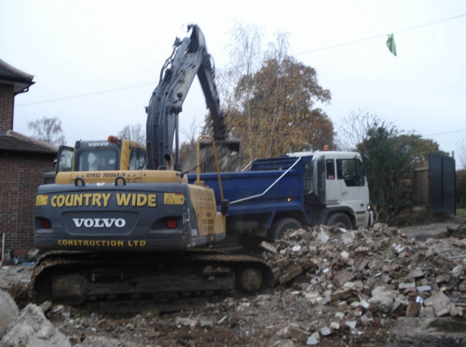 A Countrywide Contractors excavator loading demolition rubble into a tipper